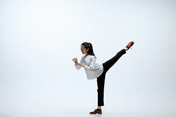 Image showing Woman working at office and jumping isolated on studio background