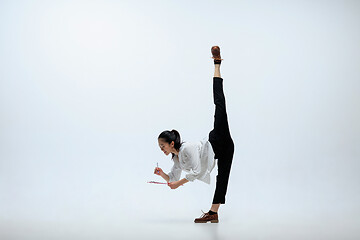 Image showing Woman working at office and jumping isolated on studio background