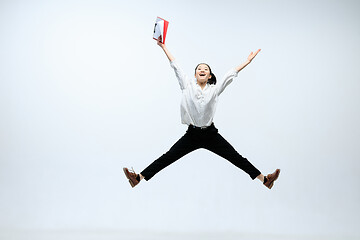 Image showing Woman working at office and jumping isolated on studio background