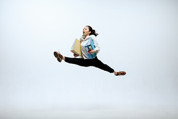 Image showing Woman working at office and jumping isolated on studio background