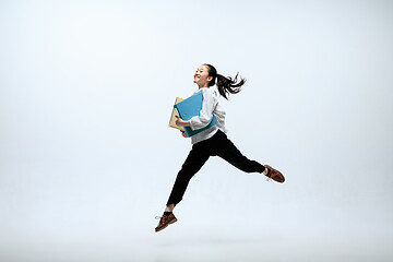 Image showing Woman working at office and jumping isolated on studio background