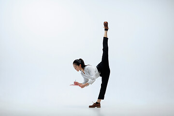 Image showing Woman working at office and jumping isolated on studio background