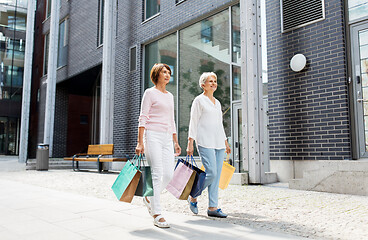 Image showing senior women with shopping bags walking in city
