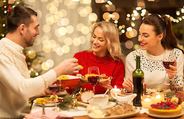 Image showing happy friends having christmas dinner at home