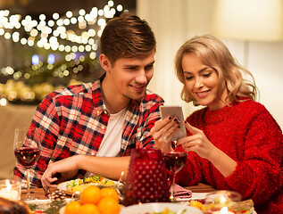 Image showing couple with smartphone at home christmas dinner