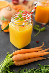 Image showing mason jar glass of orange juice with paper straw