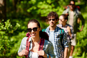 Image showing group of friends with backpacks hiking in forest