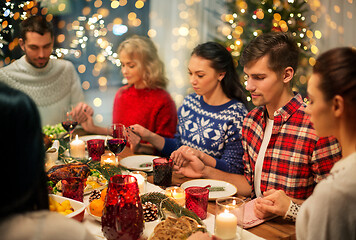 Image showing friends having home christmas dinner and praying