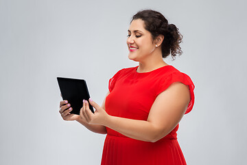 Image showing happy woman in red dress using tablet computer