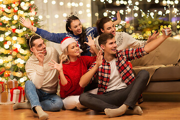 Image showing friends celebrating christmas and taking selfie