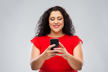 Image showing happy woman in red dress using smartphone