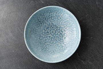 Image showing close up of blue ceramic plate on slate background