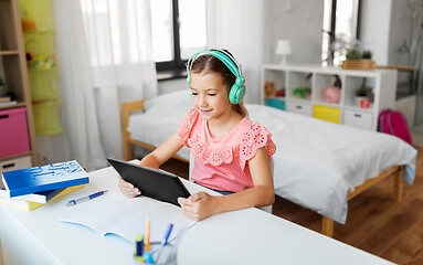 Image showing girl in headphones with tablet computer at home