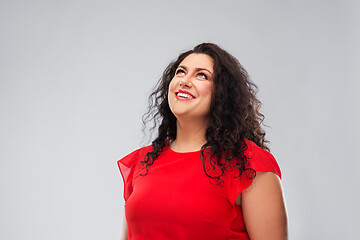 Image showing happy smiling woman in red dress looking up