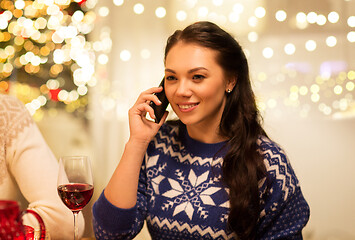 Image showing woman calling on smartphone at christmas dinner