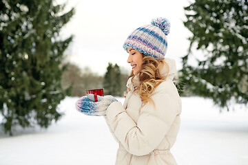 Image showing happy young woman with tea cup outdoors in winter