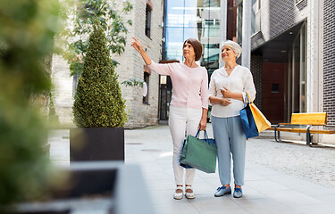 Image showing senior women with shopping bags walking in city