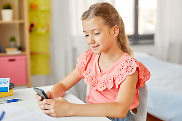 Image showing happy student girl using smartphone at home