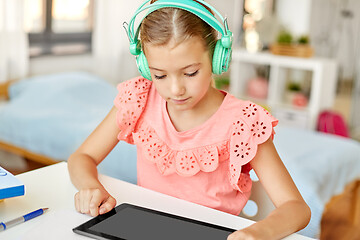 Image showing girl in headphones with tablet computer at home