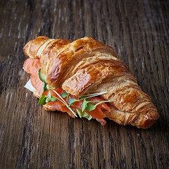 Image showing Fresh croissant with salmon and greens