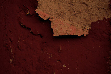 Image showing Detail of flaking plaster on a dark red wall