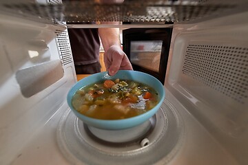 Image showing Heating food in a microwave oven