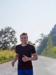 Image showing man jogging along a country road