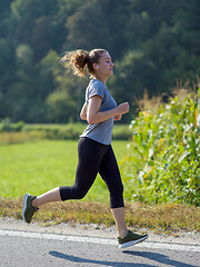 Image showing woman jogging along a country road