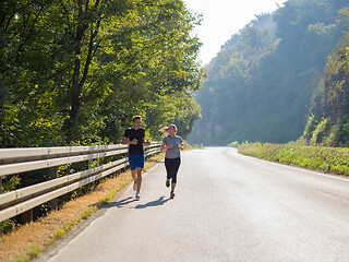 Image showing young couple jogging along a country road