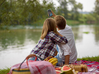 Image showing Couple taking a selfie by mobile phone while enjoying picnic tim