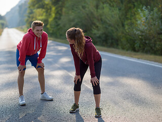 Image showing young couple warming up and stretching on a country road