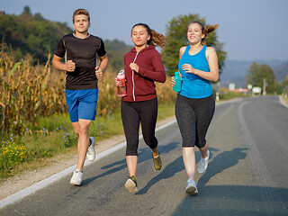 Image showing young people jogging on country road