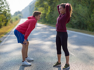 Image showing young couple warming up and stretching on a country road