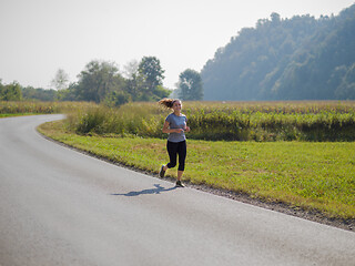 Image showing woman jogging along a country road