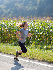 Image showing woman jogging along a country road