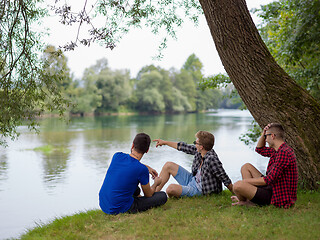 Image showing men sitting on the bank of the river