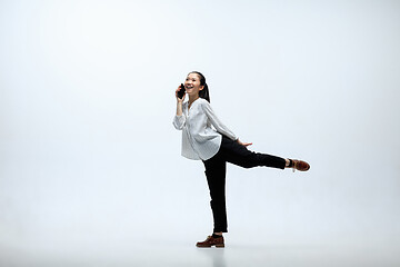 Image showing Woman working at office and jumping isolated on studio background