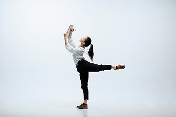 Image showing Woman working at office and jumping isolated on studio background