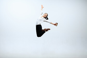 Image showing Woman working at office and jumping isolated on studio background