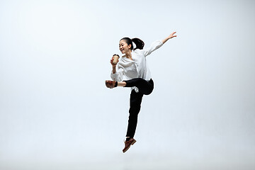 Image showing Woman working at office and jumping isolated on studio background