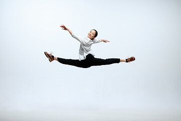 Image showing Woman working at office and jumping isolated on studio background