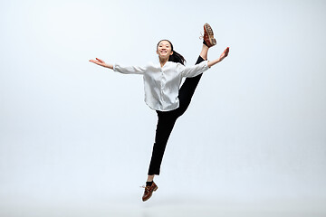 Image showing Woman working at office and jumping isolated on studio background