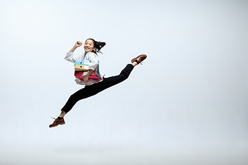 Image showing Woman working at office and jumping isolated on studio background