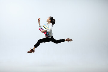 Image showing Woman working at office and jumping isolated on studio background