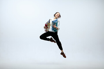 Image showing Woman working at office and jumping isolated on studio background