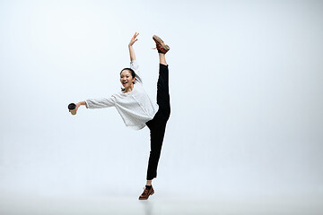 Image showing Woman working at office and jumping isolated on studio background