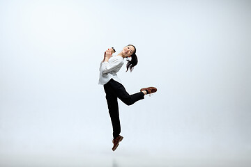 Image showing Woman working at office and jumping isolated on studio background