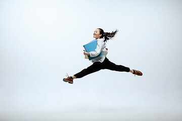 Image showing Woman working at office and jumping isolated on studio background