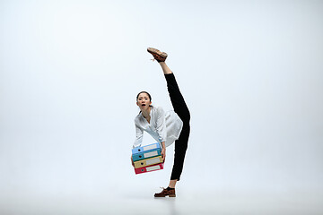 Image showing Woman working at office and jumping isolated on studio background