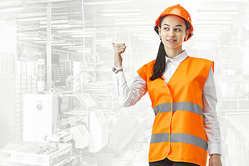 Image showing Destroying gender stereotypes. Female builder standing against industrial background